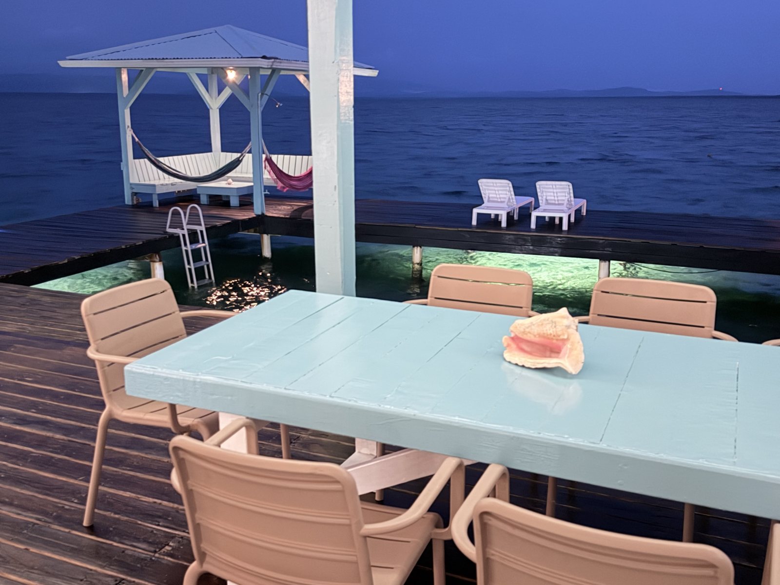 Dining table on the deck at dusk over the water