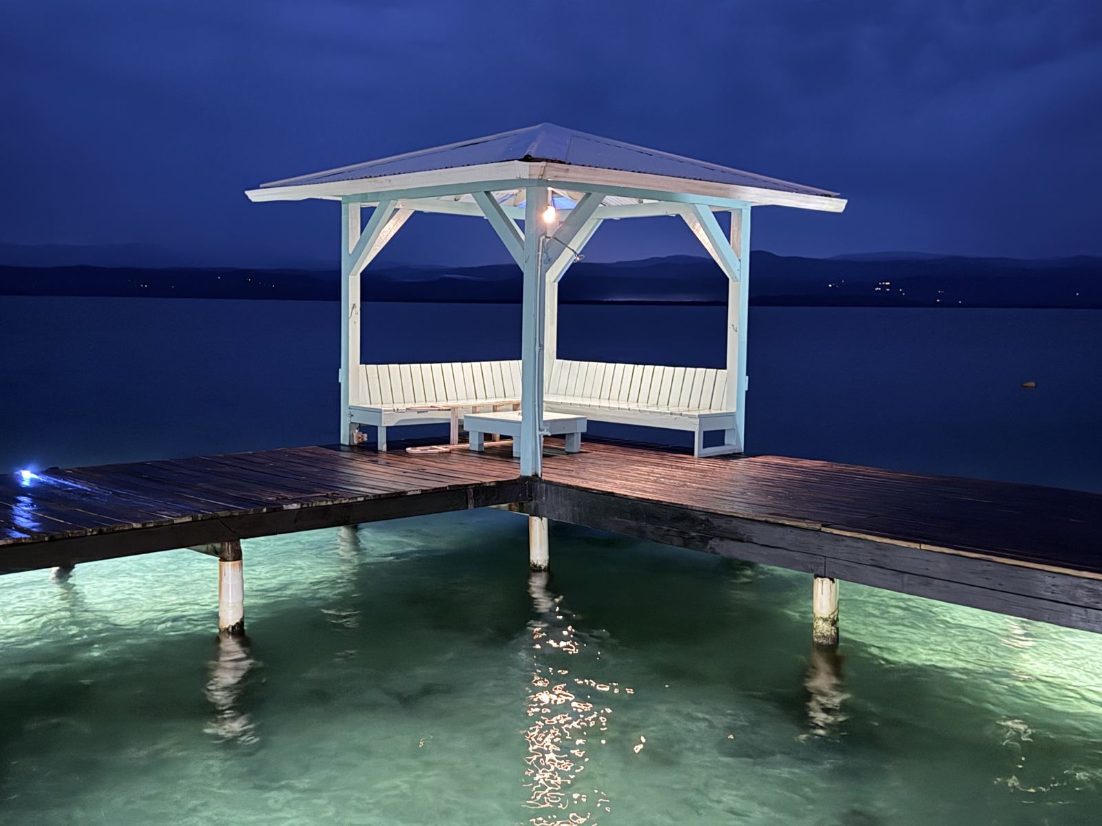 Lit gazebo at the end of the Casa Clearwater dock at night